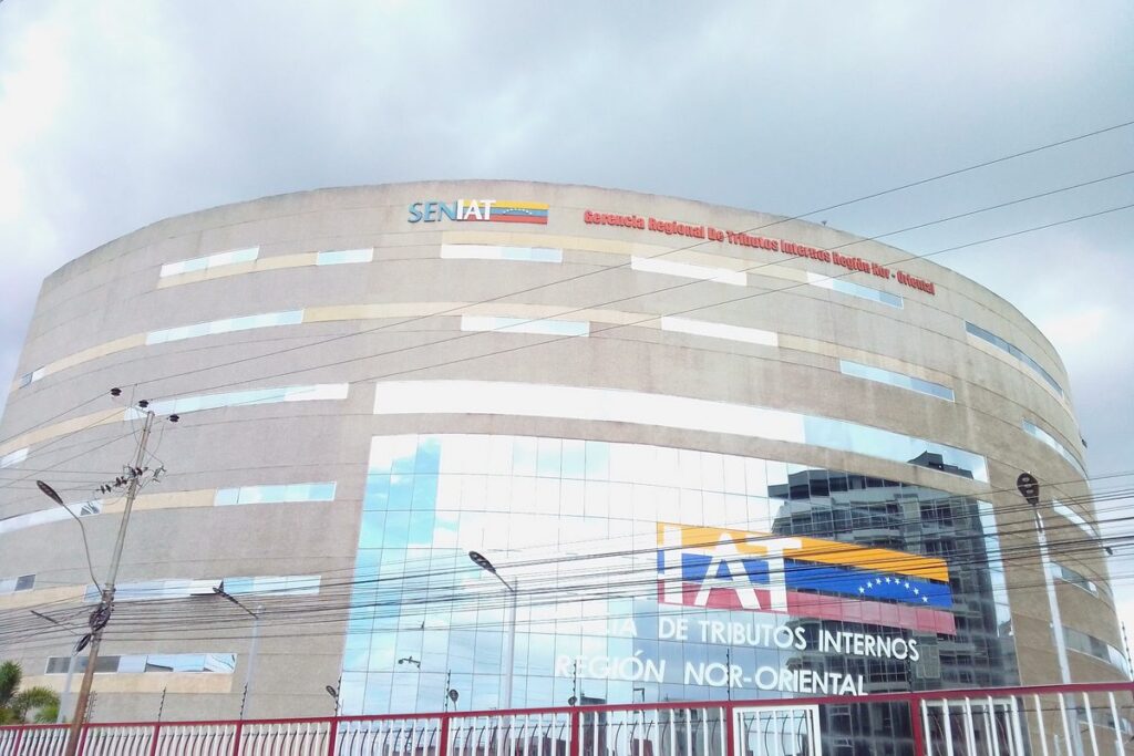 Edificio redondeado de la oficina regional del Seniat en Lechería, con el logo del Seniat en la fachada.