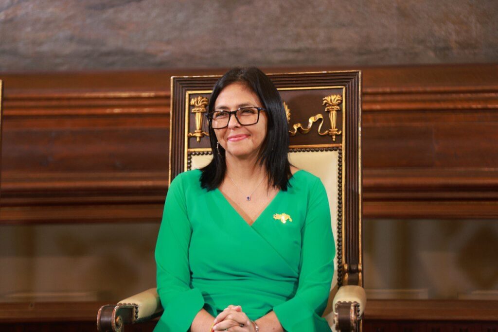 Delcy Rodríguez, con vestido verde, sentada en una silla de madera tallada durante un acto oficial en enero de 2026.